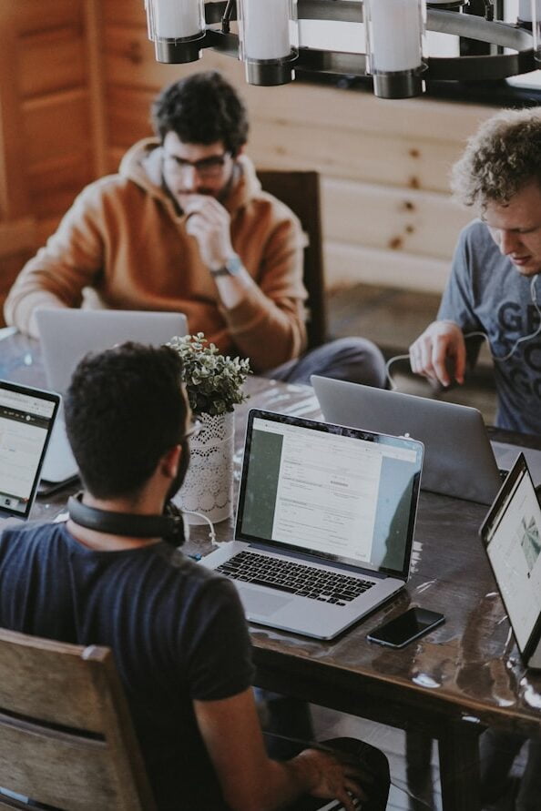 men sitting in front of their laptop computer